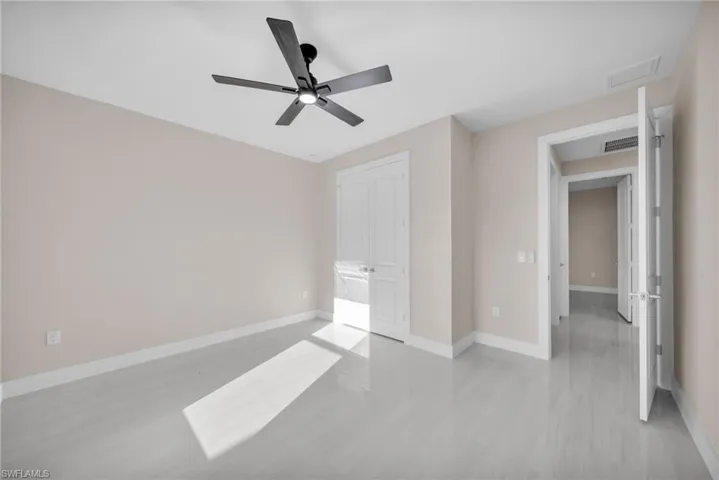 Unfurnished bedroom featuring ceiling fan and a closet
