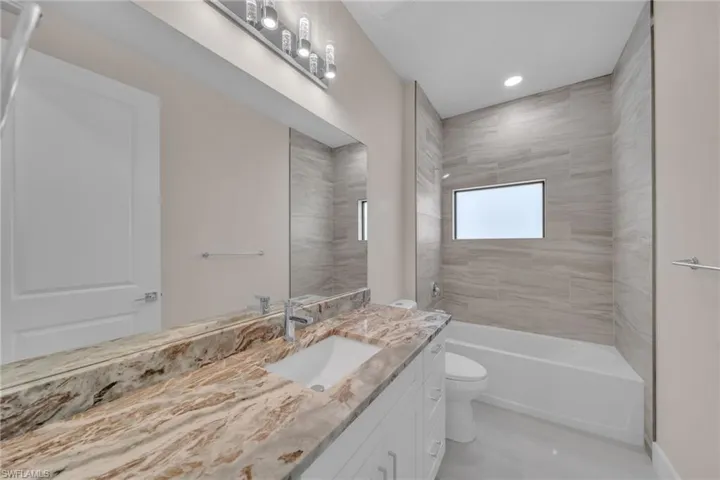 Full bathroom with vanity, shower / washtub combination, and recessed lighting