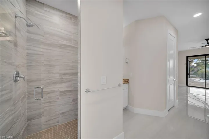 Full bath featuring a stall shower, ceiling fan, and vanity