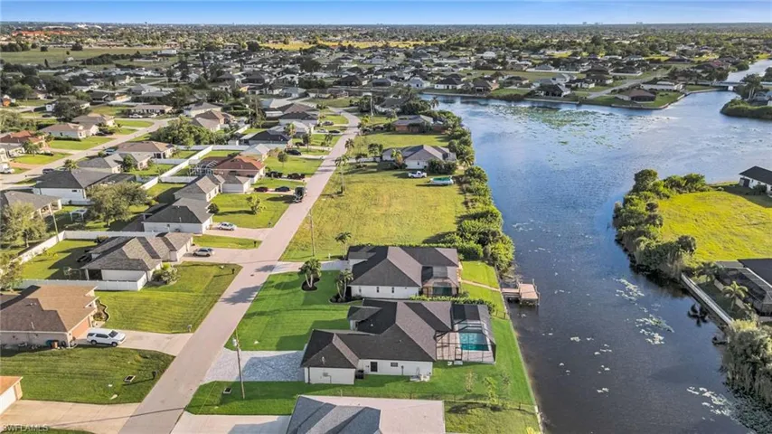Aerial view of property and surrounding area with nearby suburban area and a large body of water