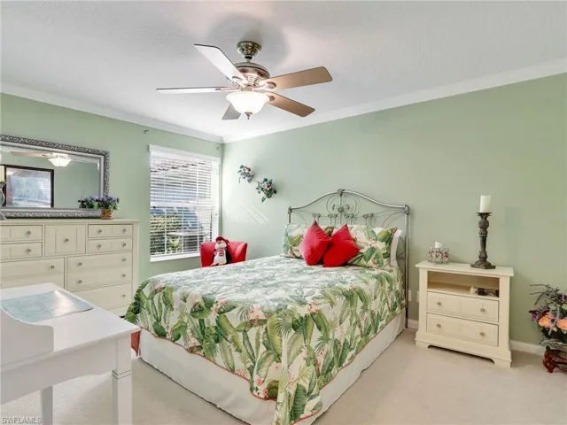 Bedroom featuring light carpet, ceiling fan, a textured ceiling, and crown molding