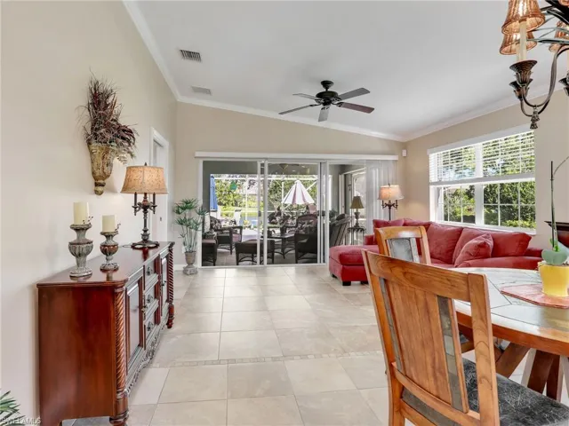 Dining area featuring ornamental molding, light tile flooring, ceiling fan, and vaulted ceiling