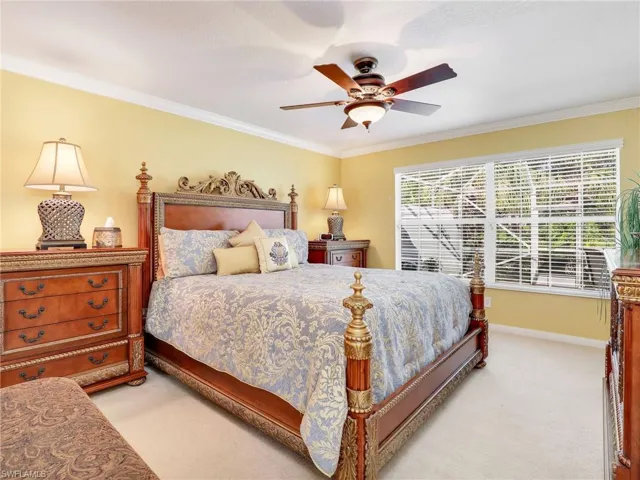 Carpeted bedroom with crown molding and ceiling fan
