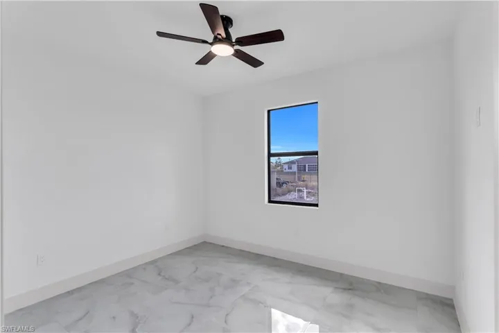 Empty room with light marble finish flooring and ceiling fan