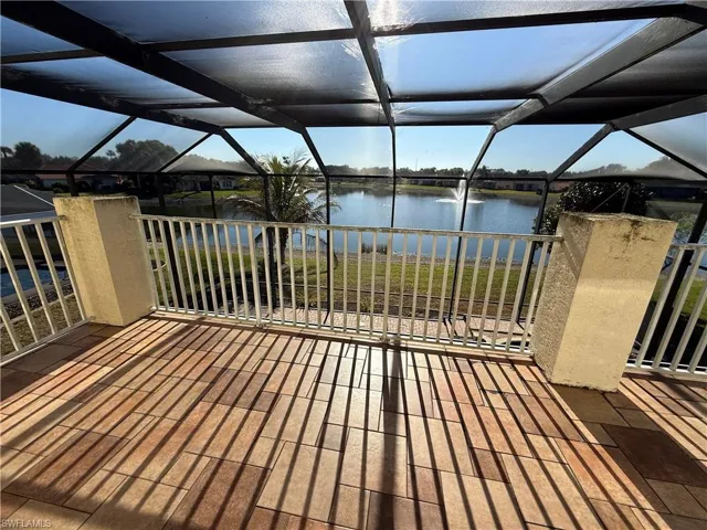 Wooden terrace with a sunroom, a water view, and glass enclosure