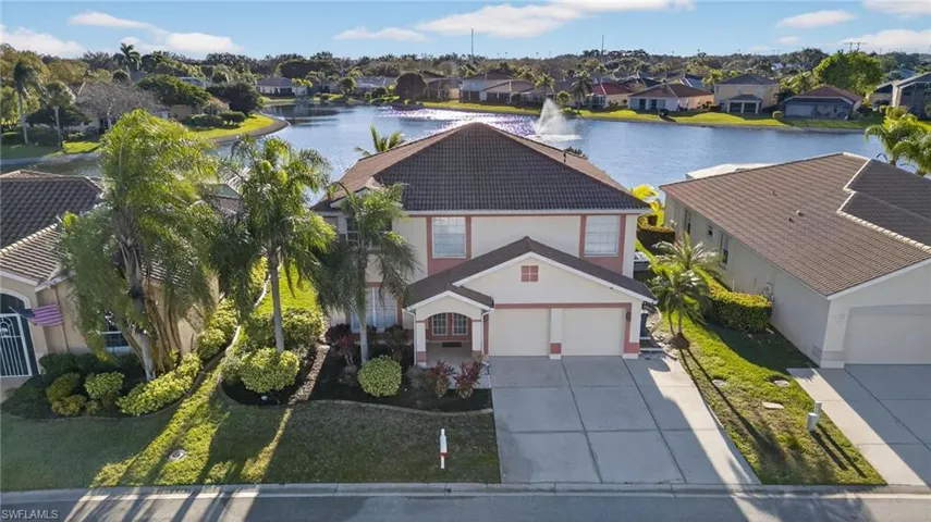 View of front facade featuring driveway, stucco siding, and a front lawn