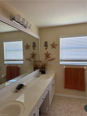 Bathroom featuring double vanity and light tile patterned floors