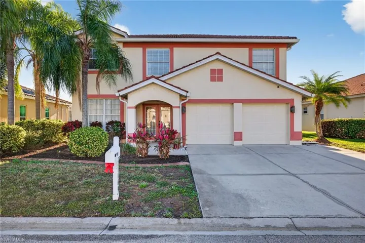 View of front of property featuring a water view, stucco siding, driveway, a tiled roof, and a residential view