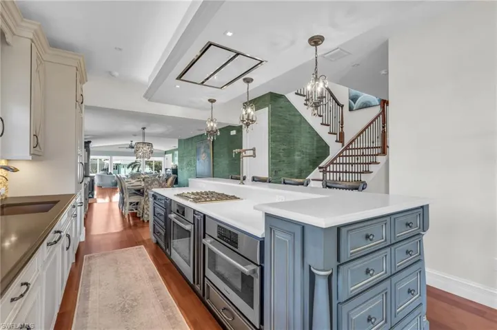 Kitchen with a chandelier, dark wood finished floors, decorative light fixtures, and blue cabinets