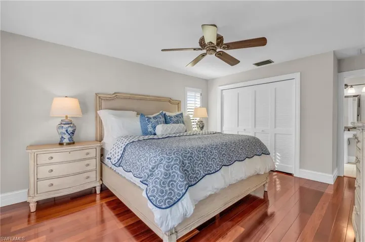 Bedroom with hardwood / wood-style floors, a closet, and a ceiling fan