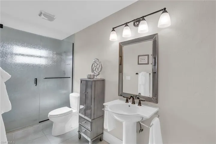 Full bath with a shower stall and tile patterned floors