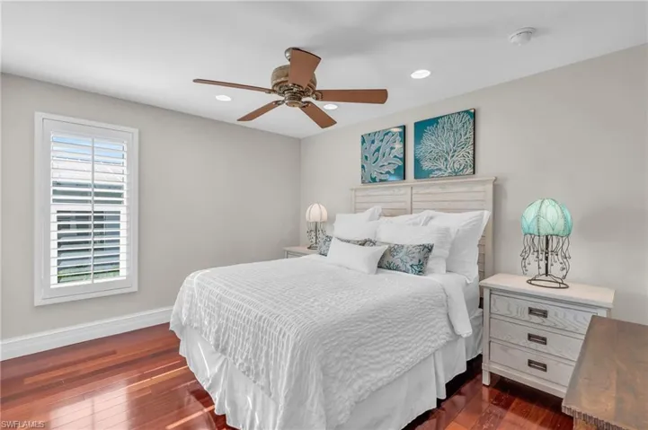 Bedroom with dark wood-style flooring, ceiling fan, and recessed lighting