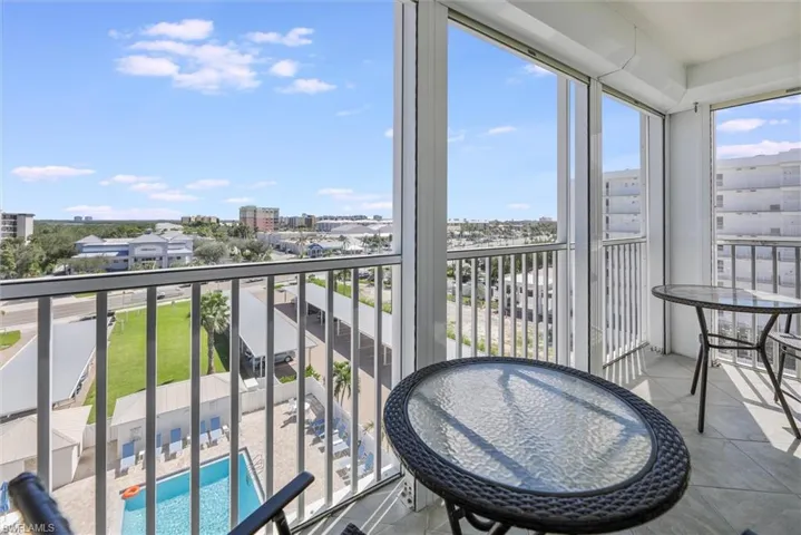 Balcony featuring view of pool and a sunroom