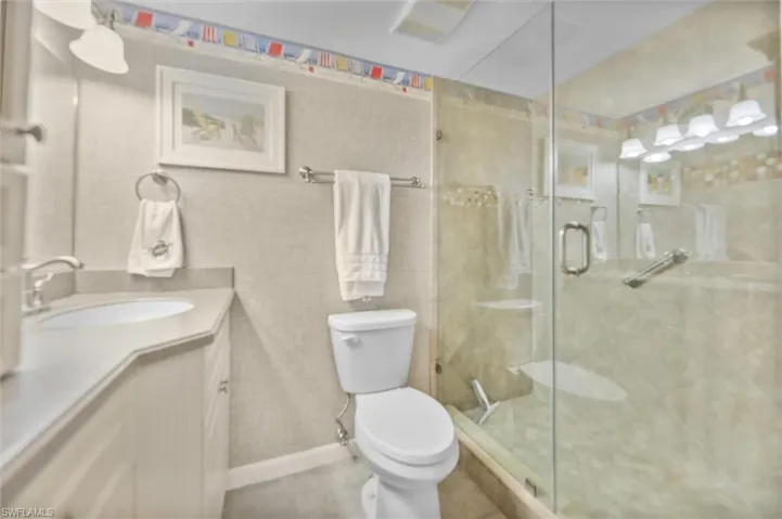 Full bathroom with vanity, a stall shower, tile walls, and tile patterned floors