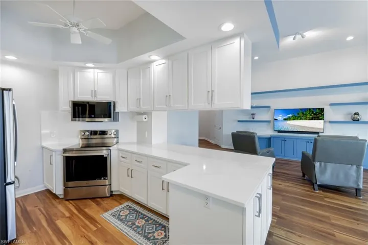 Kitchen featuring stainless steel appliances, white cabinets, a peninsula, a ceiling fan, and recessed lighting