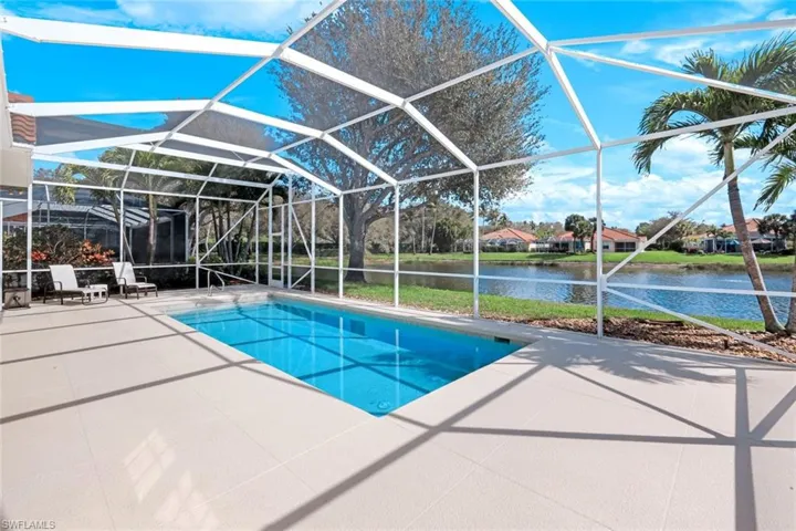 Swimming pool with a sunroom, a lanai, a patio area, and a water view