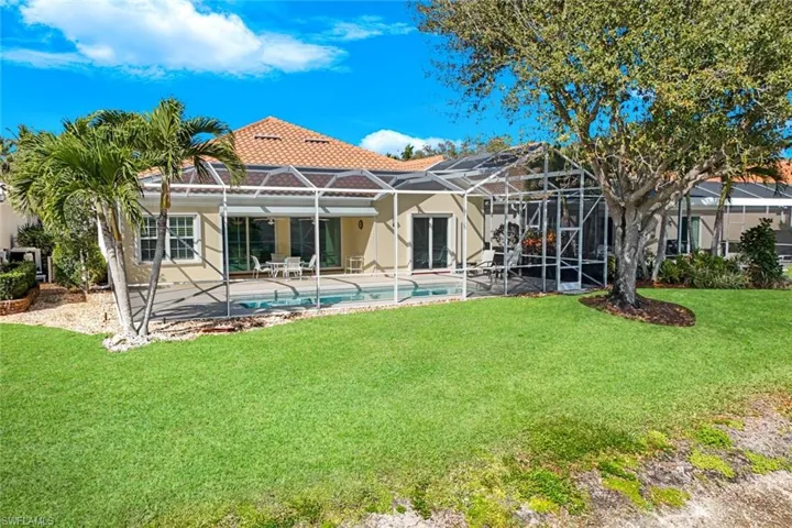 Back of house featuring an outdoor pool, a patio area, a sunroom, a yard, and stucco siding
