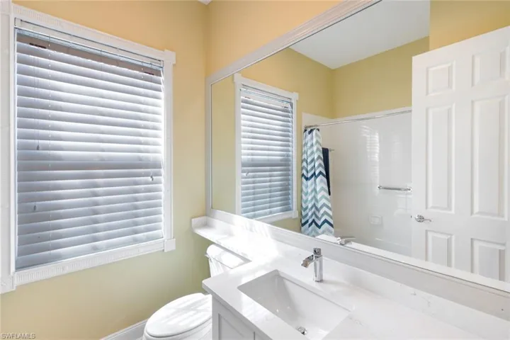 Bathroom featuring vanity, curtained shower, and healthy amount of natural light