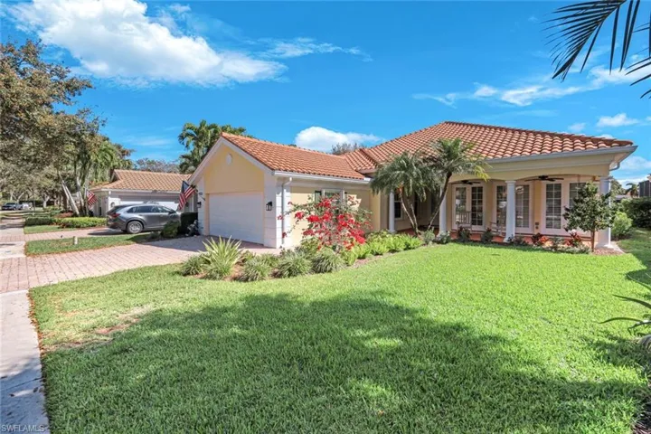 Mediterranean / spanish-style home featuring a tile roof, a front lawn, stucco siding, an attached garage, and driveway