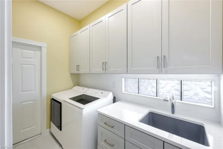 Laundry area featuring separate washer and dryer and cabinet space