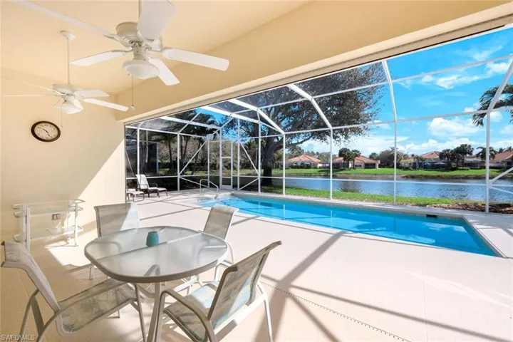Outdoor pool with a sunroom, a patio area, a lanai, a residential view, and a water view