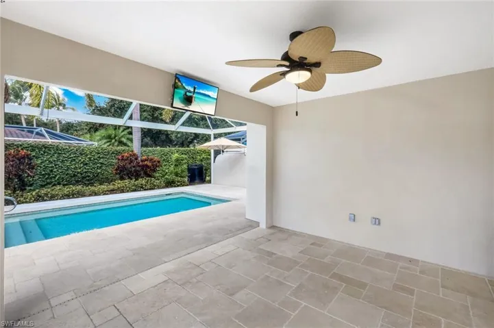 Swimming pool featuring a ceiling fan, a patio, a sunroom, and glass enclosure