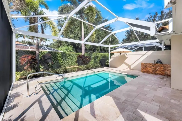 View of pool with a sunroom, a patio, and glass enclosure