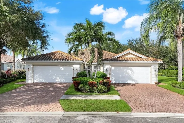 View of front of home with a tile roof, stucco siding, and decorative driveway