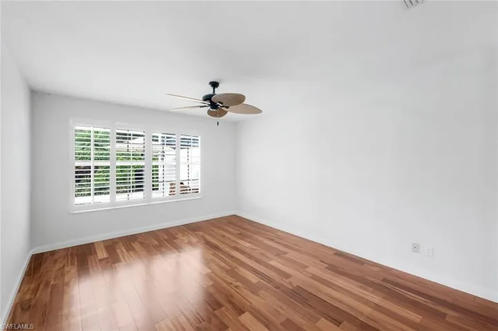 Empty room with wood finished floors and a ceiling fan