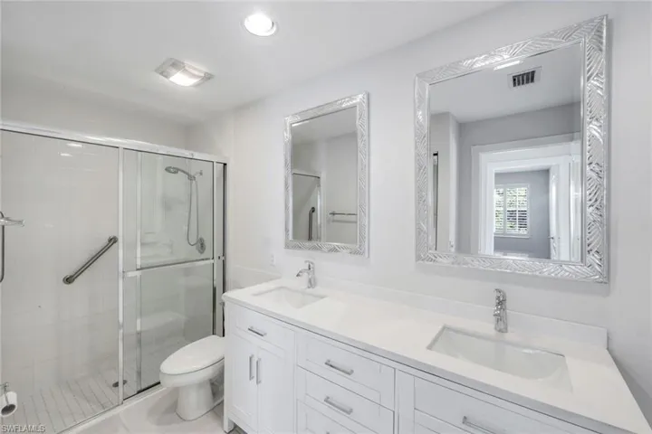 Full bath with a stall shower, double vanity, recessed lighting, and light tile patterned flooring