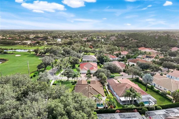 Aerial view of residential area with a nearby body of water and a local golf course