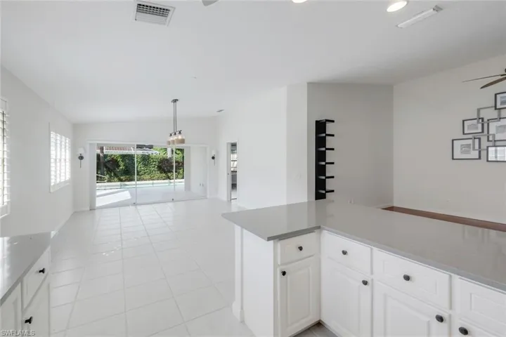 Kitchen with a ceiling fan, white cabinetry, light tile patterned flooring, recessed lighting, and light stone counters
