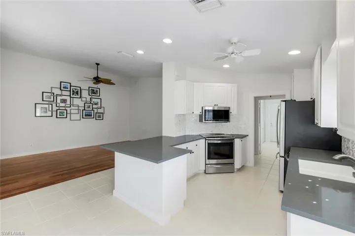 Kitchen featuring a ceiling fan, light tile patterned flooring, decorative backsplash, appliances with stainless steel finishes, and recessed lighting