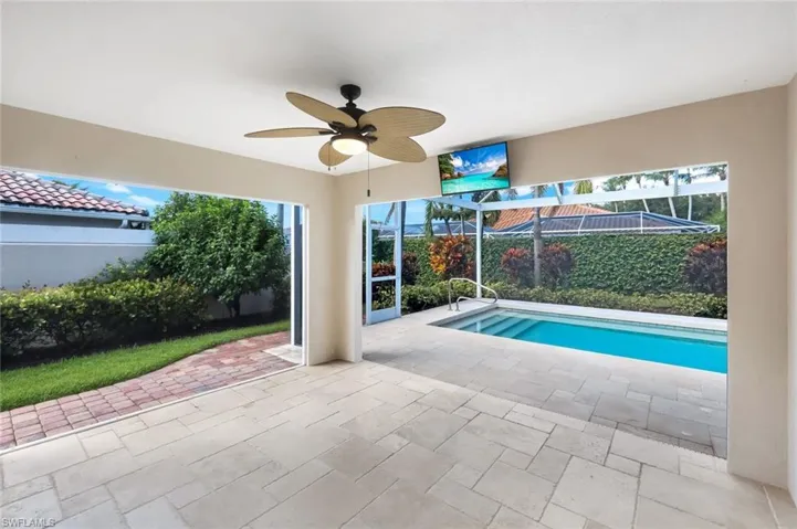 View of swimming pool featuring ceiling fan, a patio, and a lanai