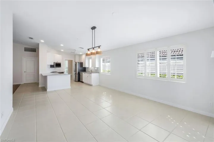 Unfurnished living room with light tile patterned floors and recessed lighting
