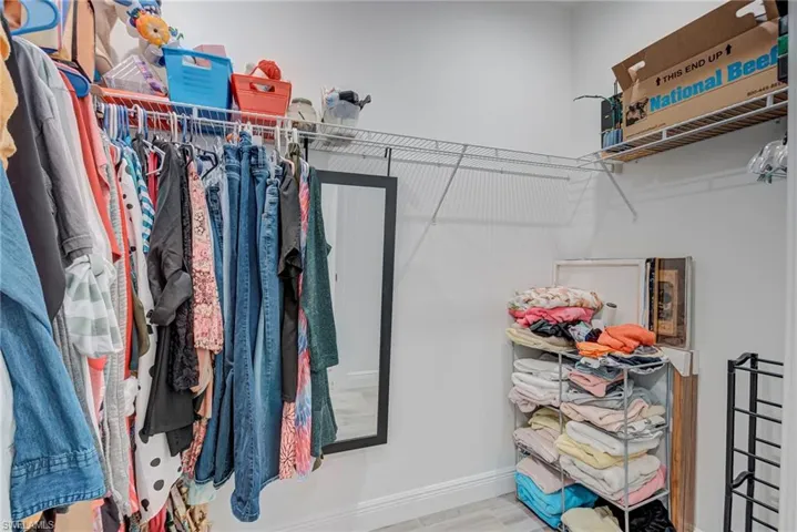 Walk in closet with light wood-type flooring