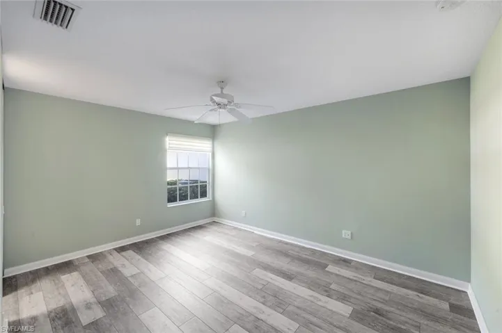 Empty room with light wood-style floors and ceiling fan
