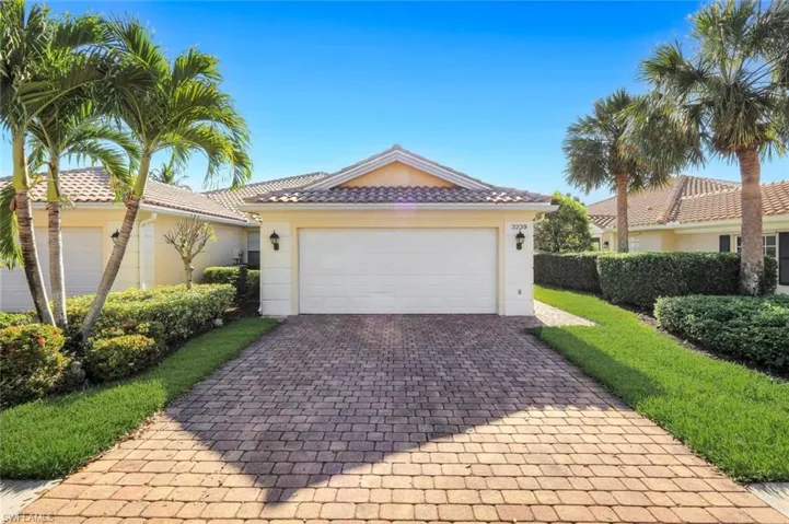 Single story home with decorative driveway, a tiled roof, stucco siding, and an attached garage