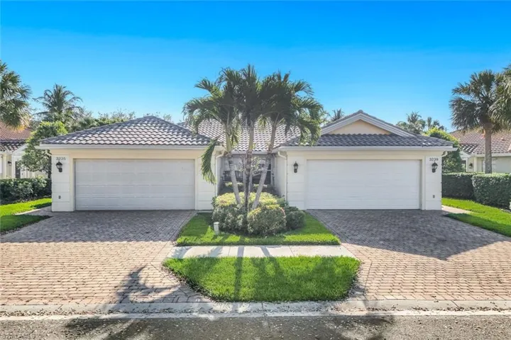 Ranch-style house with driveway, a tile roof, an attached garage, and stucco siding