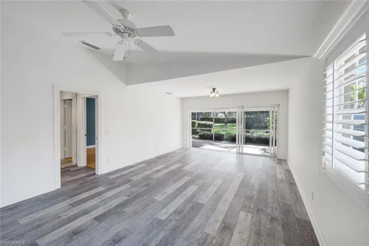 Unfurnished living room with wood finished floors and a ceiling fan