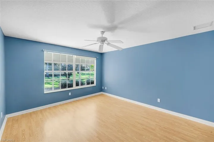 Empty room with a textured ceiling, light wood-style floors, and a ceiling fan