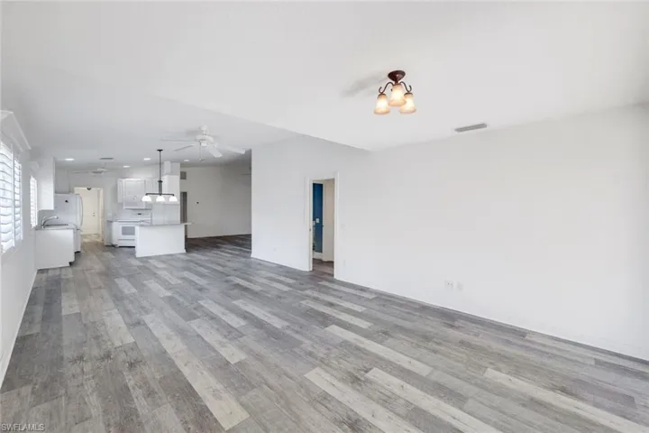 Unfurnished living room featuring light wood finished floors, ceiling fan, and recessed lighting