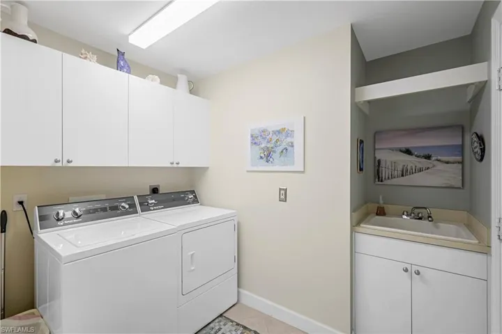 Laundry room has more storage, new washer and dryer, sink.