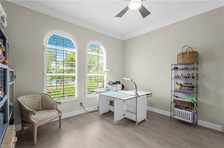 2nd bedroom features luxury vinyl flooring, crown molding and an abundance of natural light spilling in.  Custom plantation shutters, ceiling fan, and crown molding