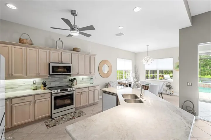The kitchen has a new island, quartzite countertops, dazzling backsplash. NEW SAMSUNG GLASS BESPOKE appliances that are 6 months old!  New lighting, under cabinet lighting and fans.