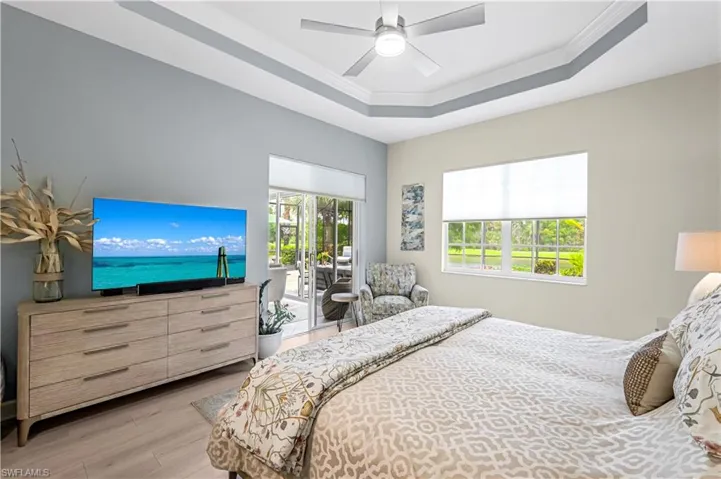 Master wing features a tray ceiling, crown molding, new ceiling fan,luxury vinyl flooring, and access to your lanai.