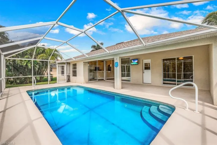 View of swimming pool with a lanai and a patio