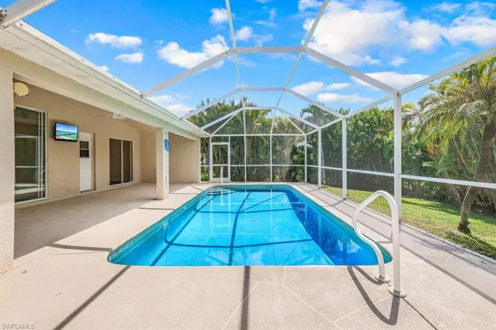 View of pool with a lanai, ceiling fan, and a patio