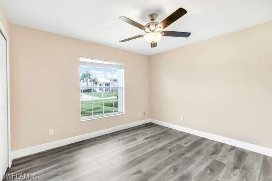 Spare room with ceiling fan and dark hardwood / wood-style flooring