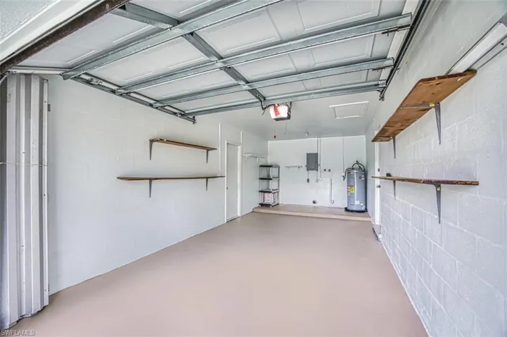 Garage featuring concrete block wall and water heater